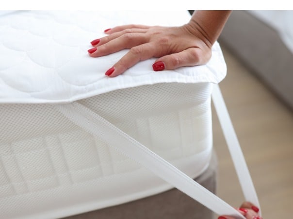 https://www.dreamcloudsleep.com/wp-content/uploads/2022/03/woman-puts-blanket-or-mattress-topper-on-bed-closeup-picture-id1345064131.jpg